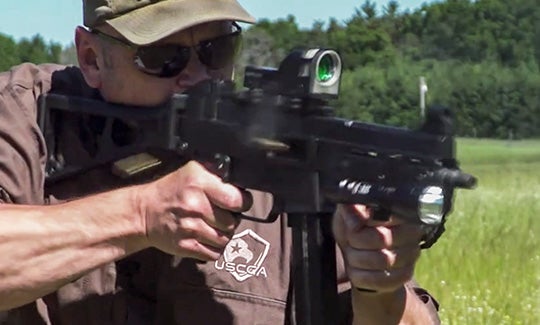 man shooting fully automatic rifle